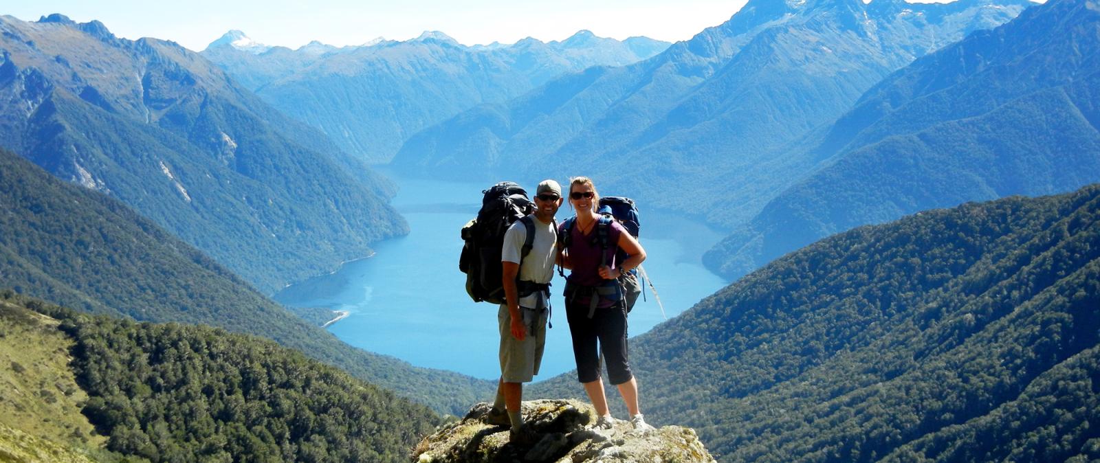 Couple hiking the remote Kepler Tack, with a backdrop of mountains and lakes.