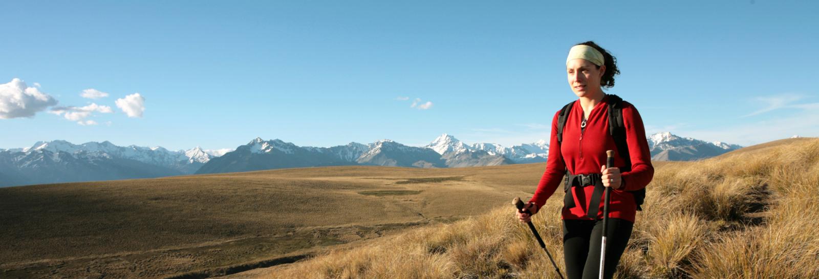 Trekking the Lake Tekapo high Country, a girl makes her way through tussock country.