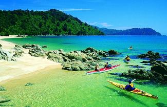 Kayaks meander in the idillic Abel Tasman National Park.